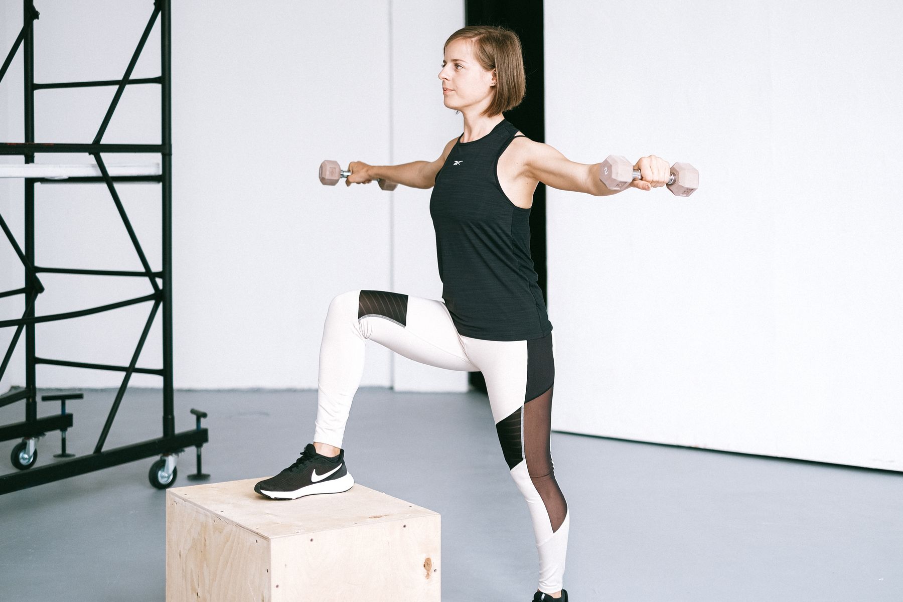 Woman training with dumbbells in a bright gym